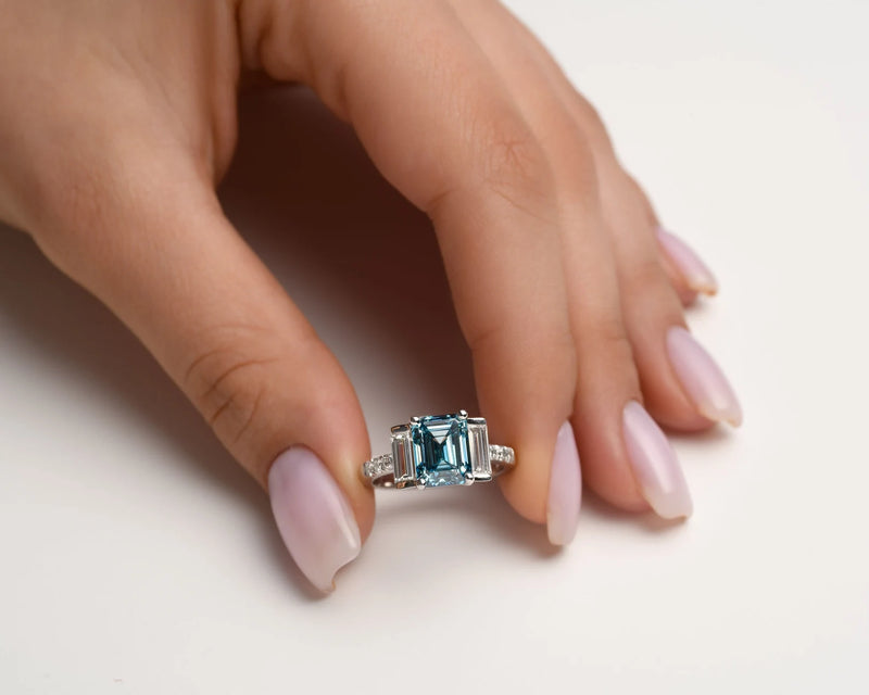 18K Solid Gold 4ct Fancy Blue Natural Diamond Emerald Cut Three Stone Engagement Ring - Alternate Angle | Riyanika Jewels